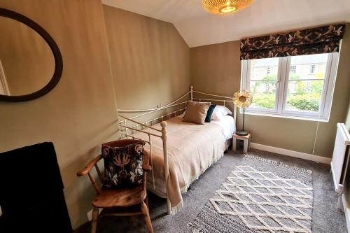 um quarto com uma cama, um espelho e uma cadeira em Gorgeous Two Bedroom House in Ely em Ely