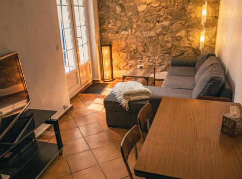 uma sala de estar com um sofá e uma mesa em Maison de caractère climatisée avec terrasses em Plan-de-la-Tour