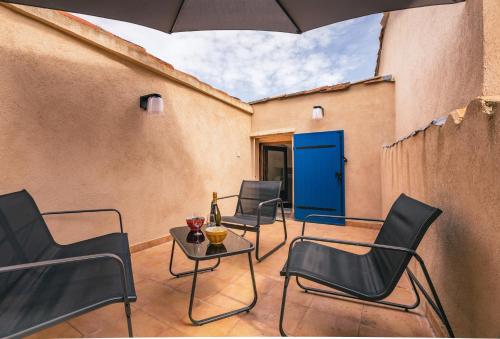 um pátio com cadeiras e uma mesa com uma porta azul em Maison de caractère climatisée avec terrasses em Plan-de-la-Tour