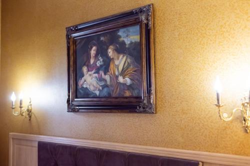 a painting of a man holding a baby on a wall at Hotel Am Ring in Sibiu