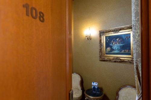 a bathroom with a toilet and a painting on the wall at Hotel Am Ring in Sibiu