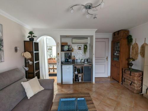 a living room with a couch and a kitchen at L'Instant Mer - Bord de Mer - Studio avec grand jardin à La Capte in Hyères