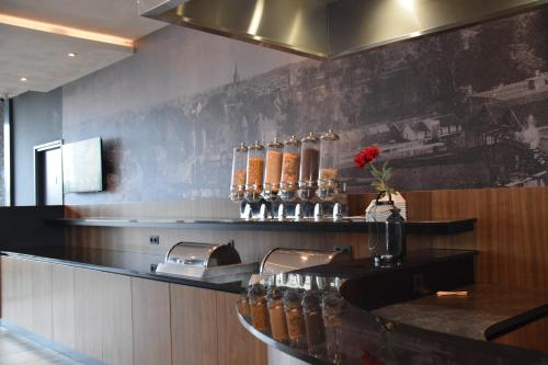 eine Küche mit einer Theke mit Glasflaschen darauf in der Unterkunft Bastion Hotel Amersfoort in Amersfoort