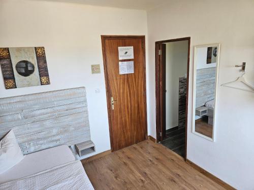 a room with a bed and a wooden door at SEVEN Hostal in Cala Millor