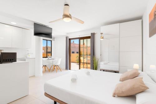 Biała sypialnia z dużym łóżkiem i kuchnią w obiekcie MEDANO4YOU White Dream Penthouse w mieście El Médano