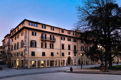 a large building on the side of a street at Grand Universe La Residenza in Lucca