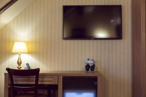 a hotel room with a desk with a television on the wall at Hotel Am Ring in Sibiu