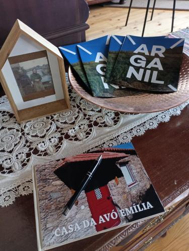 a table with books and a picture and a picture frame at Casa da Avó Emília in Arganil