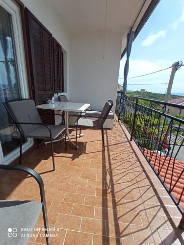 a patio with a table and chairs on a balcony at Apartment Skale in Senj