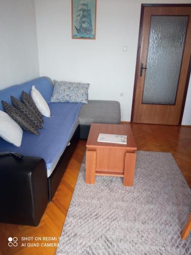 a living room with a blue couch and a coffee table at Apartment Skale in Senj