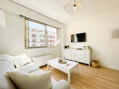 a white living room with a couch and a table at Studio bord de mer 3 in Menton