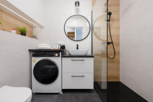 a bathroom with a washing machine and a sink at Wellness Resort & SPA Dziwnów Apartments with Parking by Noclegi Renters in Dziwnów