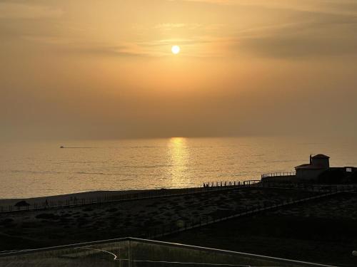 a sunset over the ocean with the sun setting at Povoa de Varzim-Sleeps4-Beachfront-Ac-Parking in Póvoa de Varzim