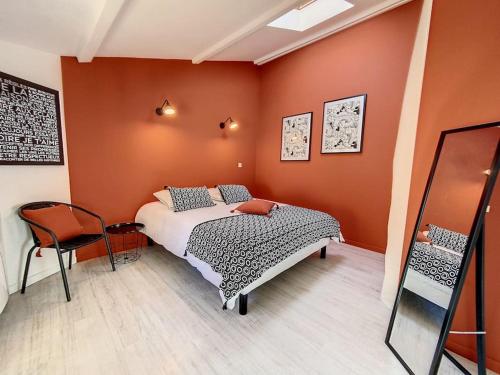 um quarto com uma cama num quarto com paredes cor-de-laranja em Bienvenue à la Tatoo Room em Bourgoin-Jallieu