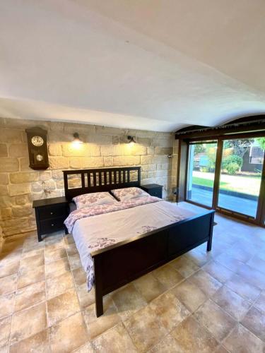 een slaapkamer met een groot bed in een stenen muur bij Apartment Holín in Holín