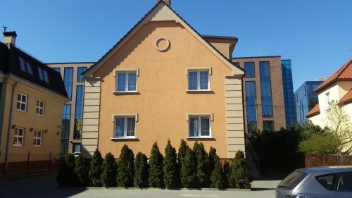 a yellow house with a triangle shaped roof at Villa Lena in Gdańsk
