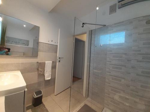 a bathroom with a glass shower and a sink at APARTMAN EDDA **** in Labin
