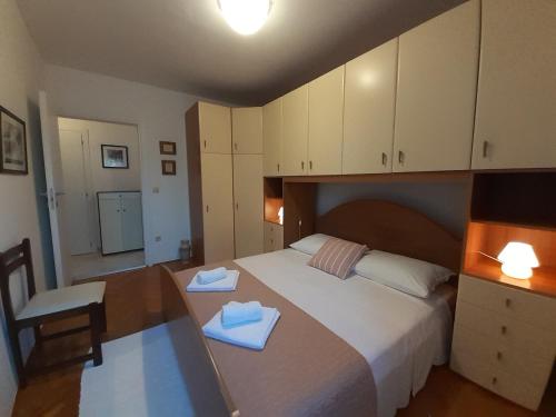 a bedroom with a large bed with two towels on it at APARTMAN EDDA **** in Labin