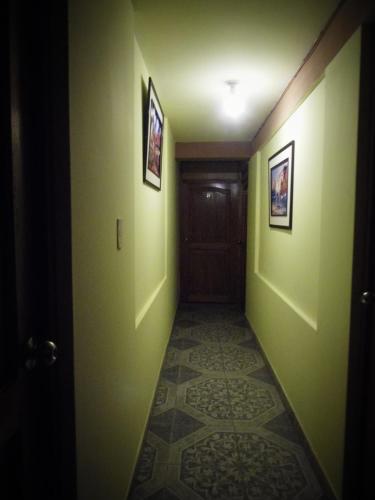a hallway with green walls and a door at Hostal Pablo's House in Machu Picchu