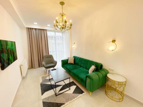 ein Wohnzimmer mit einer grünen Couch und einem Stuhl in der Unterkunft City Heart Luxury Apartment in Kutaissi