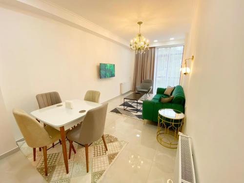 庫塔伊西的住宿－City Heart Luxury Apartment，客厅配有桌子和绿色沙发