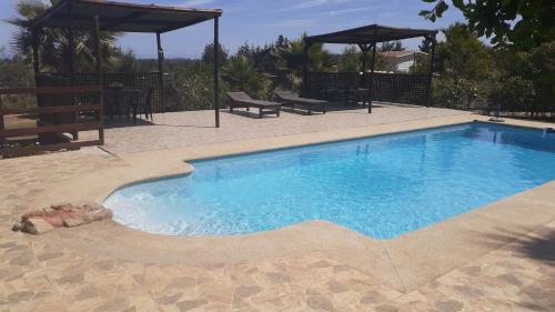 a large swimming pool with blue water in a yard at Cabañas La Querencia de Algarrobo in Algarrobo