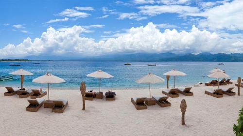 a group of chairs and umbrellas on a beach at Pearl of Trawangan in Gili Trawangan