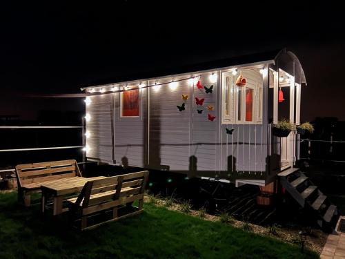 una pequeña casa blanca con luces encendidas por la noche en Ontwaken tussen de paarden, en Helen-Bos