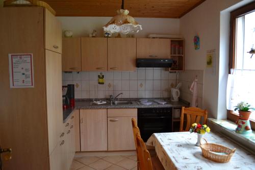 una cocina con armarios de madera y una mesa con fregadero en Ferienwohnungen Edelweiss, en Schulenberg im Oberharz