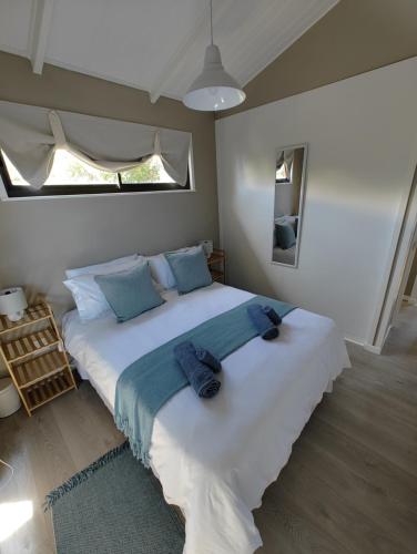 a bedroom with a large white bed with blue pillows at Aurora's Rest 47 in Fisherhaven