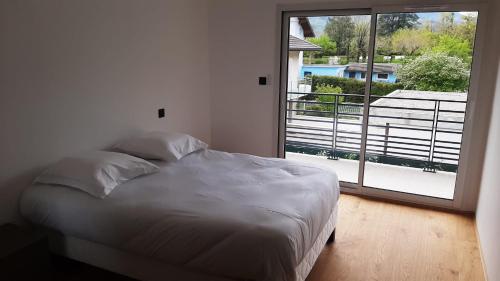 a bed in a bedroom with a large window at L'Aurore du Lac in Sévrier