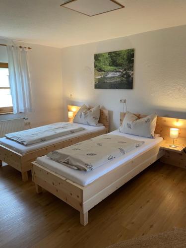 two twin beds in a room with two lamps at Ferienwohnung Hofleben Reiner in Neukirchen vorm Wald