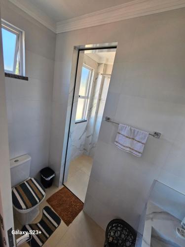 La salle de bains est pourvue d'une douche, de toilettes et d'un miroir. dans l'établissement Cobertura em Bombinhas - Piscina - Luxo - Alto Padrão, à Bombinhas
