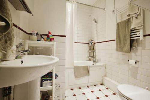 ein weißes Bad mit einem Waschbecken und einem WC in der Unterkunft Charming West London Studio Your Urban Oasis in London
