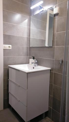 een badkamer met een witte wastafel en een spiegel bij Precioso Estudio in Sada