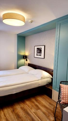 a bedroom with a large bed with a blue wall at Hotel Pestalozzi Lugano in Lugano