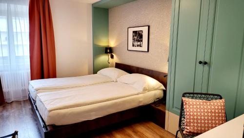 a small bedroom with a bed in a room at Hotel Pestalozzi Lugano in Lugano