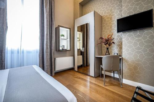 a bedroom with a bed and a desk and a mirror at Martelli 6 Suite & Apartments in Florence