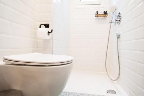 a white bathroom with a toilet and a shower at Cozy House Old Town in Xanthi - Meno Homes 1 in Xanthi