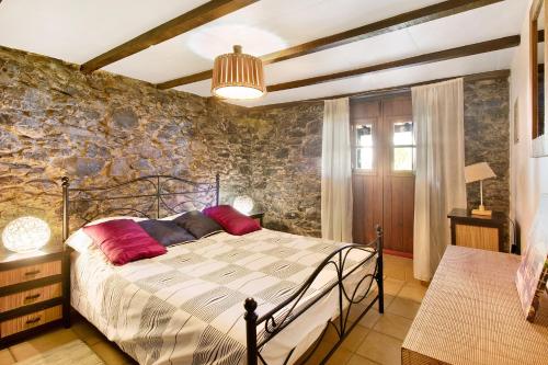 una camera con letto e parete in pietra di Villa Montemar a Calheta