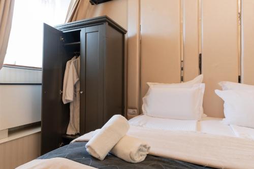 a small bedroom with a bed and a closet at Tsarevets Boutique Hotel & SPA in Veliko Tŭrnovo