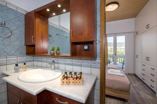 Un baño con lavabo, espejo y cama. en G & E Apartment, en Kissamos