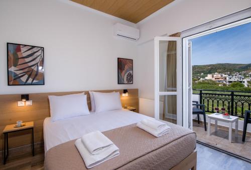 um quarto com uma cama e uma varanda com vista em G & E Apartment em Kissamos