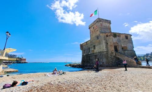 a group of people laying on a beach near the water at Casa Marina - Spacious Home in Rapallo in Rapallo