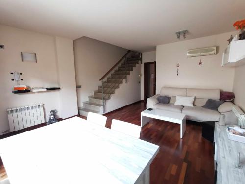 a living room with a white couch and stairs at Adosada con piscina comunitaria ideal familias in Barcelona