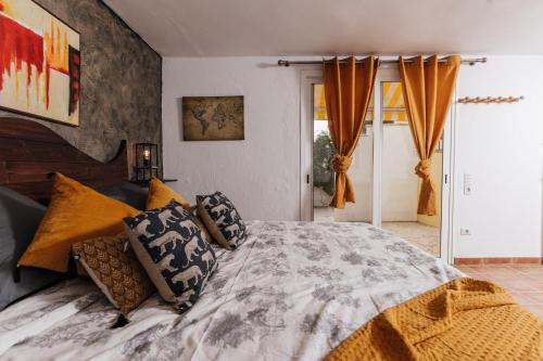 una camera da letto con un grande letto con cuscini di Hostel Los Amigos Yoga & Wellness a La Mareta
