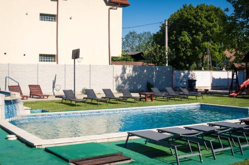 a swimming pool with lounge chairs and a poolvisorvisor at Pensiunea Casa Porojan in Baile Unu Mai