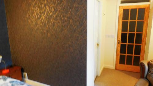 Pokój z brązową ścianą z drzwiami w obiekcie Amen Corner w mieście Greetham