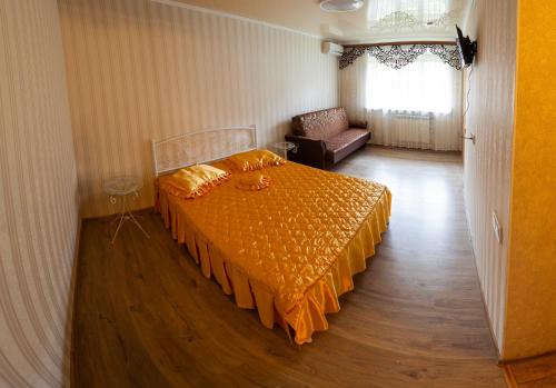 a bedroom with a bed with an orange bedspread at Luxury apartment Gagarina street in Kryvyi Rih
