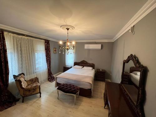 a bedroom with a bed and a chair and a chandelier at Villa trabzon in Çağlayan